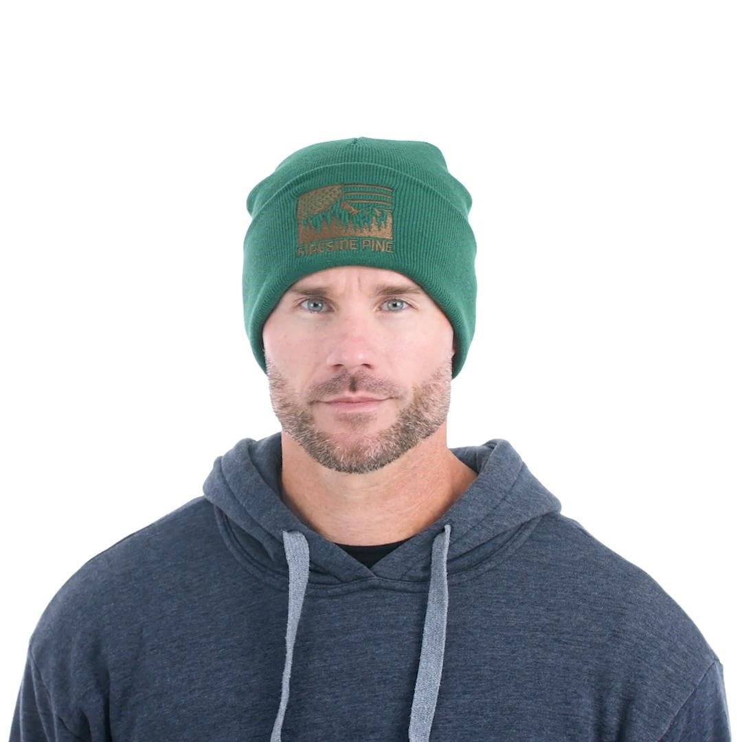 Made in USA. 100% Acrylic Knit beanie. Measuring approximately 12 inches long. Green colored beanie featuring the Fireside Pine American Flag Mountain logo embroidered on the front. Model Fit Video.