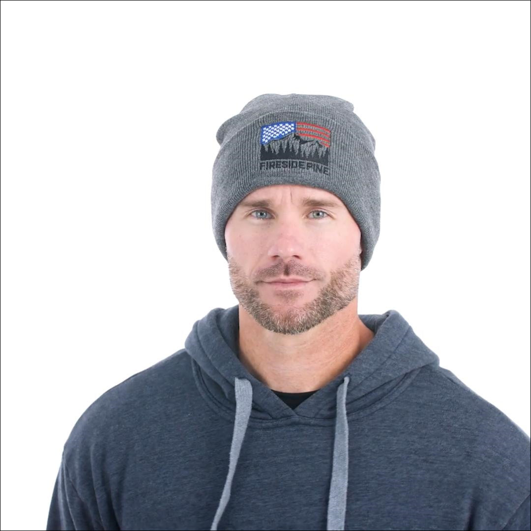 Made in USA. 100% Acrylic Knit beanie. Measuring approximately 12 inches long. Gunmetal colored beanie featuring the Fireside Pine American Flag Mountain logo embroidered on the front. Model Fit Video.